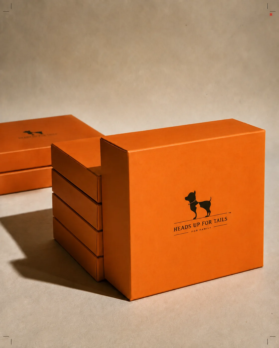 Orange Heads Up For Tails printed packaging boxes arranged in a production stack